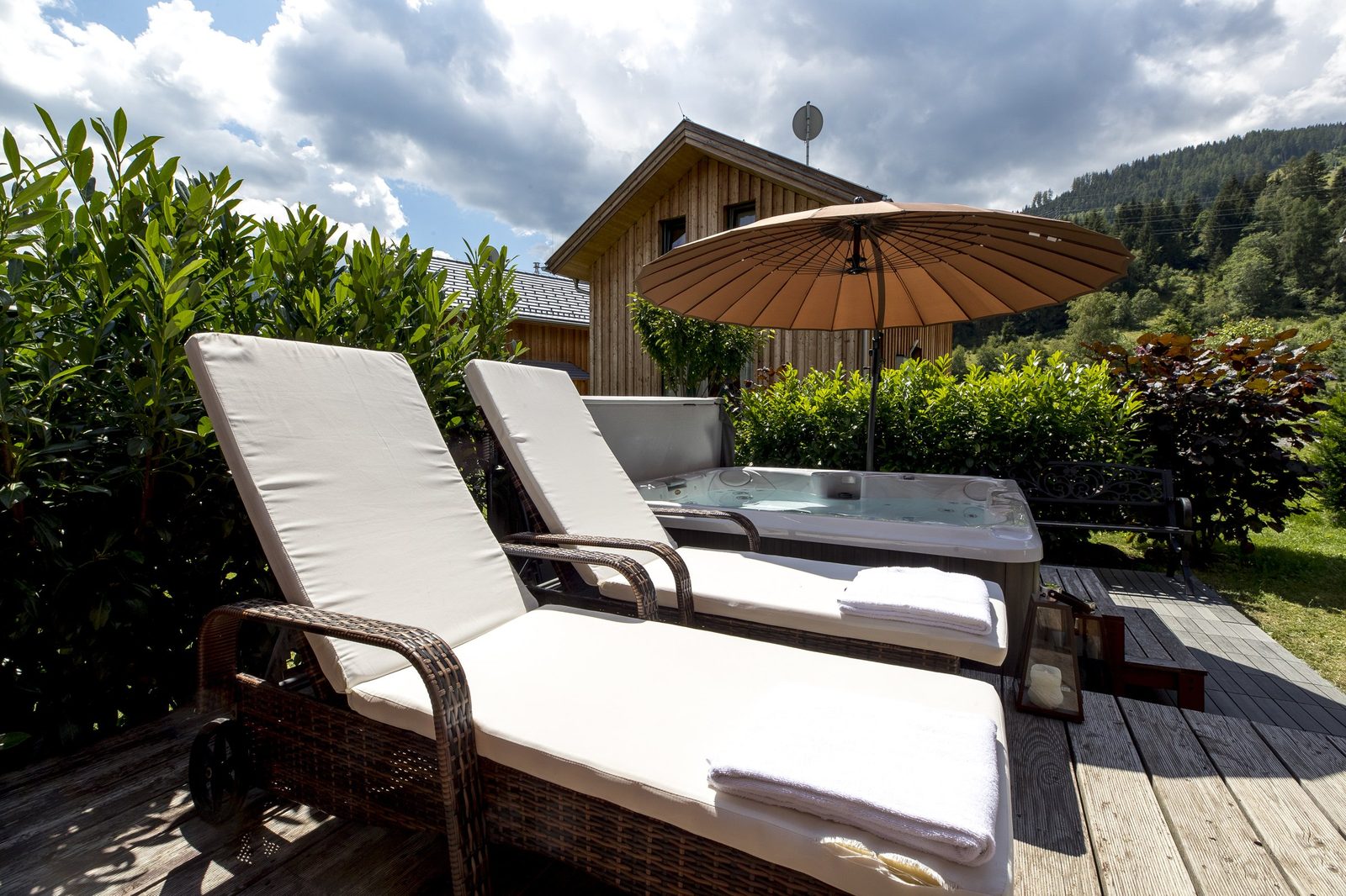 Terrasse mit Sonnenliegen und Whirlpool